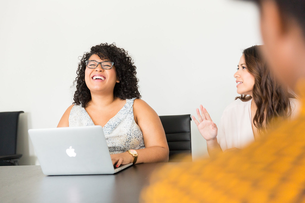 Colleagues talking in an office over a laptop